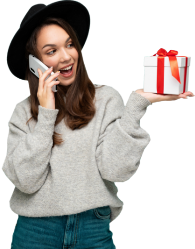 Woman smiling and holding a wrapped present while on the phone